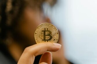 A hand holding a Bitcoin coin, representing cryptocurrency and blockchain technology investment.